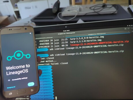 Écran de smartphone affichant "welcome to lineageos"
Derrière écran de PC avec lignes de commandes utilisant adb pour flasher la ROM