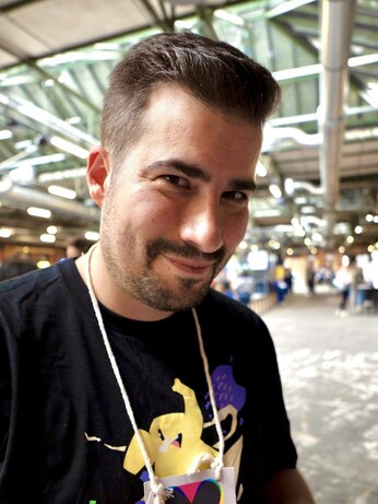 Selfie von mir mit einem schelmischen Lachen bei der re:publica 2025 mit einem Mastodon-T-Shirt an, auf dem ein Mammut fröhlich springt.