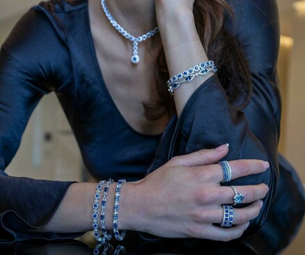 Woman wearing bracelets, necklace and rings.
