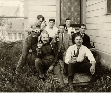 A Group Of Guys Drinking Beer Circa 1910 With A Bottle Of The Same Era.